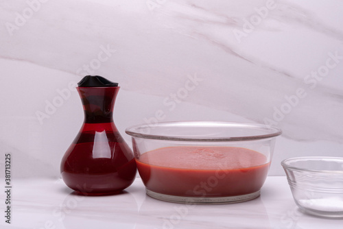 Red Tomato Sauce in glass bowl with red jar of olive oil and salt