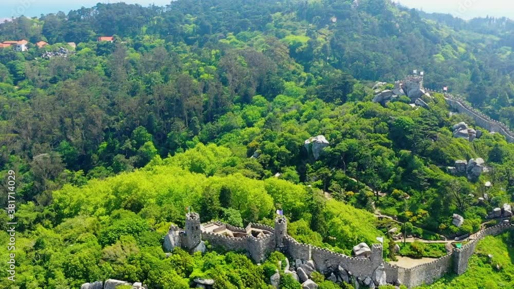 Aerial view around the Castelo dos Mouros, the Pena palace in the background, bright, sunny day, in Sintra, Lisbon, Portugal - tracking, tilt, drone shot Aerial view around the Castelo dos Mouros, the Pena palace in the background, bright, sunny day, in Sintra, Lisbon, Portugal - tracking, tilt, drone shot