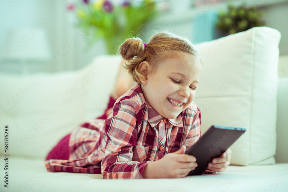 Portrait of cute little child girl with tablet at digital homeschooling
