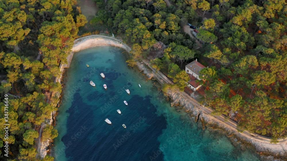 Flyover shot of a small cove protecting a group of anchored motorboats in Losinj, Croatia. Flyover shot of a small cove protecting a group of anchored motorboats in Losinj, Croatia.