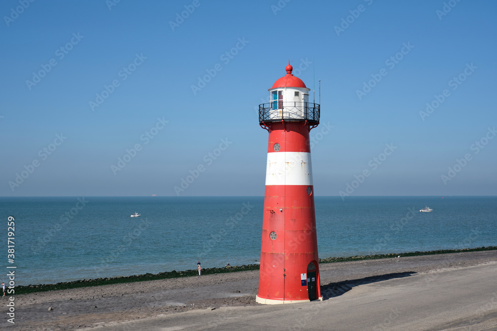 Red and white lighthouse on a blue sky background, Westkapelle, The Netherlands