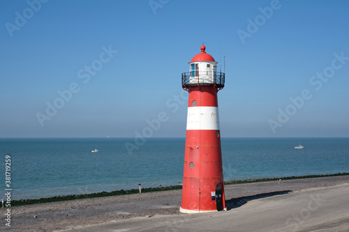 Red and white lighthouse on a blue sky background, Westkapelle, The Netherlands