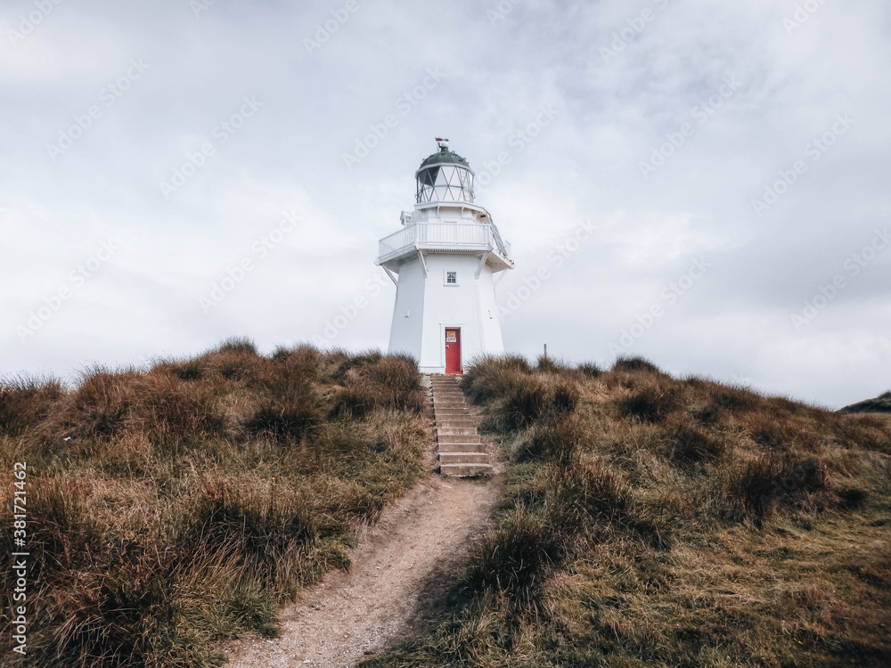 Waipapa Point Lighthouse - A Beacon on a grassy hill on New Zealand's South Island, white building with a red door Waipapa Point Lighthouse - A Beacon on a grassy hill on New Zealand's South Island, white building with a red door
