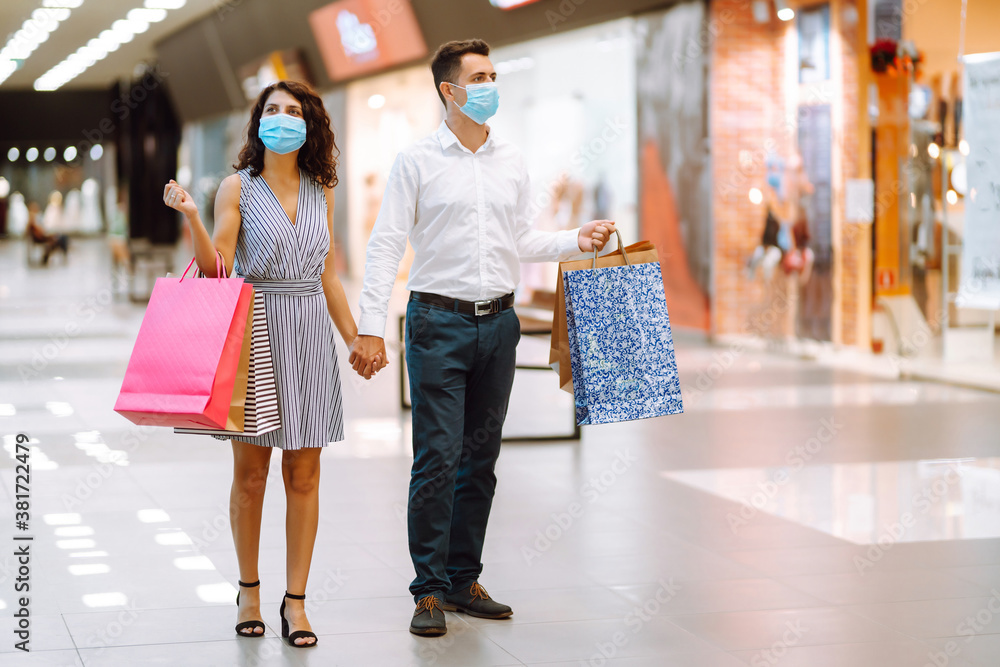 Beautiful young loving couple holding shopping bags and enjoying together purchases in mall. Consumerism, purchases, love, sales, Black friday concept. Beautiful young loving couple holding shopping bags and enjoying together purchases in mall. Consumerism, purchases, love, sales, Black friday concept.