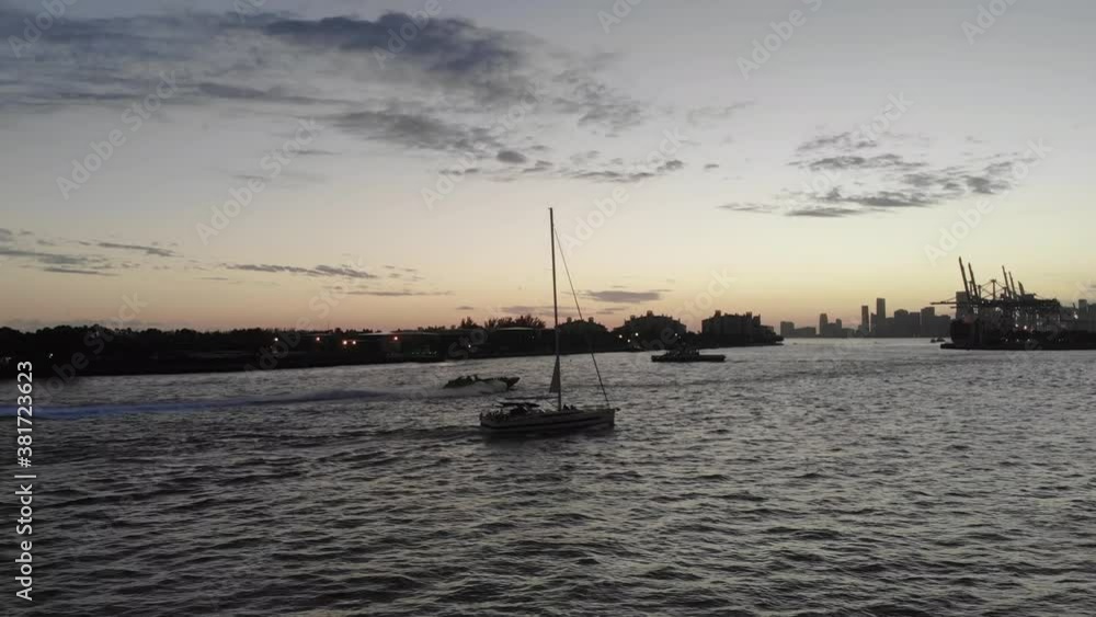 Multiple boats out on the water enjoying dusk light with Miami silhouetted in the distance Multiple boats out on the water enjoying dusk light with Miami silhouetted in the distance