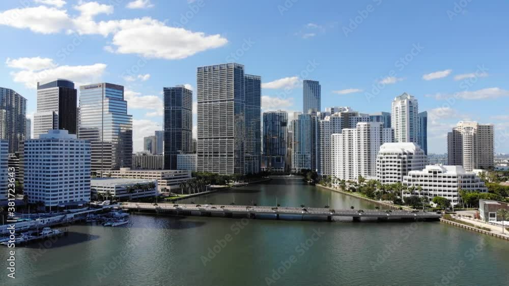 Miami downtown with high rise buildings and river flowing into city in sunshine Miami downtown with high rise buildings and river flowing into city in sunshine