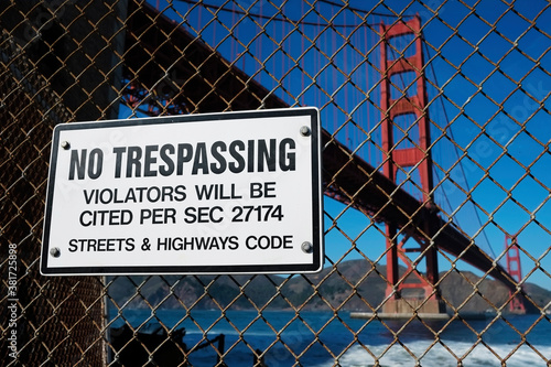 No trespassing sign Golden Gate Bridge, Fort Point fence, San Francisco, California USA. Warning alert for violation of Streets & Highways Code. Restricted, banned access roadway area. Famous landmark