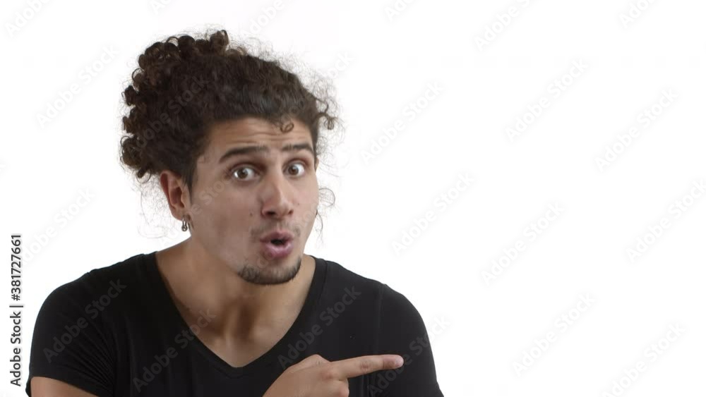 Close-up of handsome latino man with combed hair and beard, turn head and looking surprised at your logo, pointing at banner, express amazement, standing over white background Close-up of handsome latino man with combed hair and beard, turn head and looking surprised at your logo, pointing at banner, express amazement, standing over white background