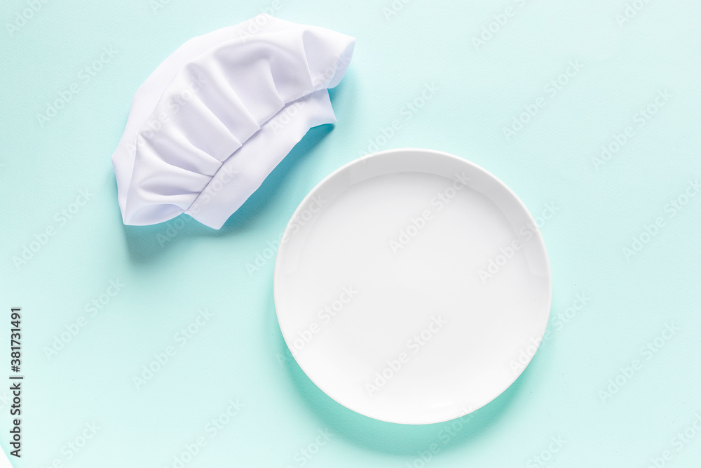 White empty plate with copy space for yout text and chef cap above. Cooking menu preparation White empty plate with copy space for yout text and chef cap above. Cooking menu preparation