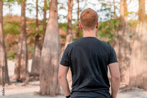 Young male tourist in cypress grove growing in Sukko lake