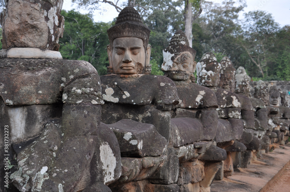 Stone heads guarding the entrance to Angkor Thom, in Angkor Wat, Cambodia
