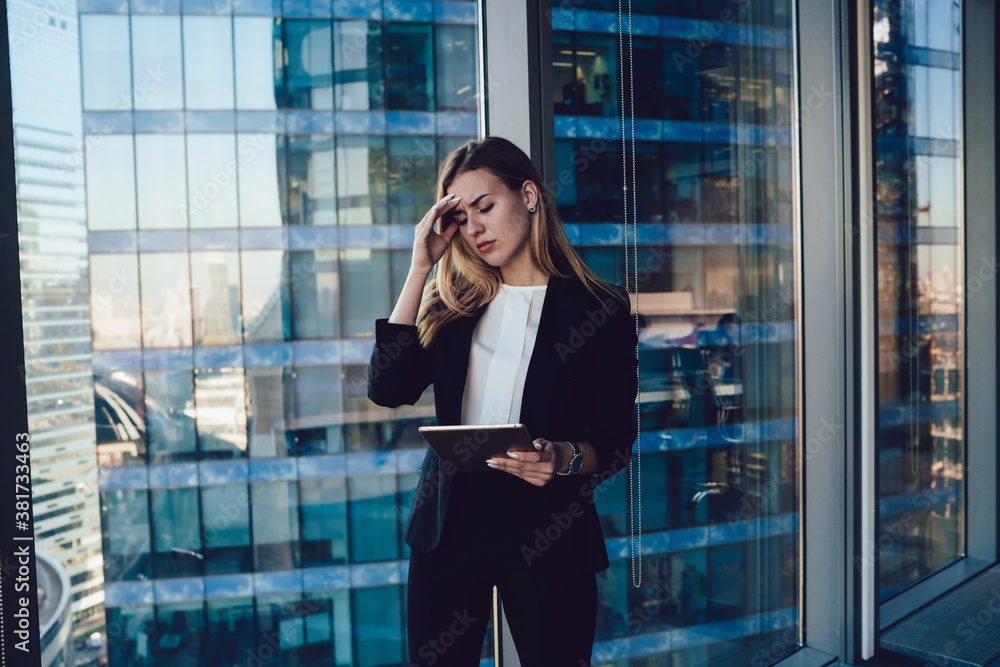 Tired businesswoman with headache using tablet in office Tired businesswoman with headache using tablet in office