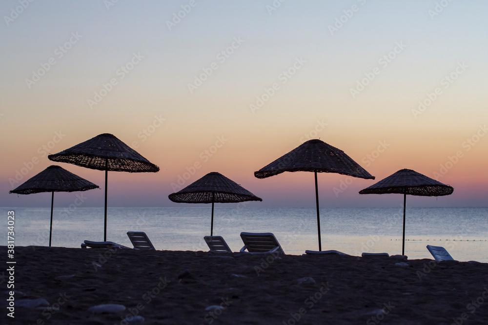 wicker umbrellas at sunrise