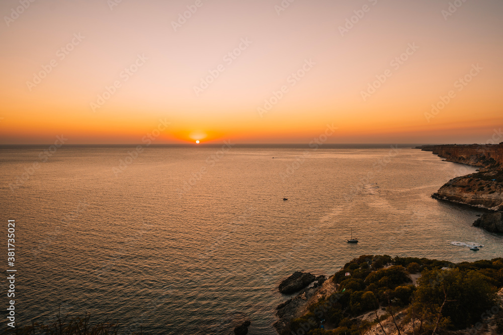 Fototapeta premium Bright sunset with large yellow sun under the sea surface