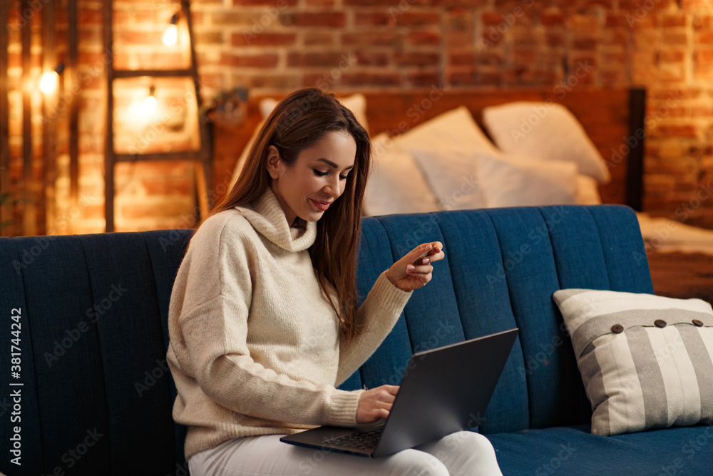 Young freelancer in home office holding credit card and using laptop. Online shopping, online payments. Booking tickets online. Modern technologies concept. Young freelancer in home office holding credit card and using laptop. Online shopping, online payments. Booking tickets online. Modern technologies concept.