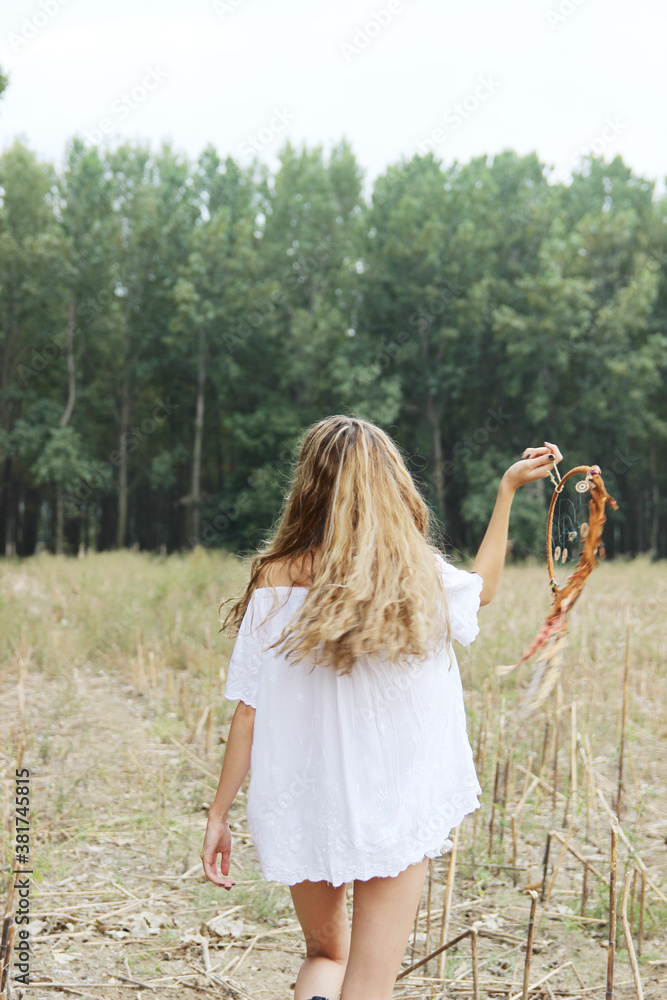 Hippie girl holds a dream catcher at the meadow. Hippie girl holds a dream catcher at the meadow.