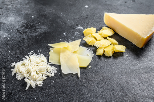 Italian hard Parmesan cheese slice, cut, grated. Black background. Top view