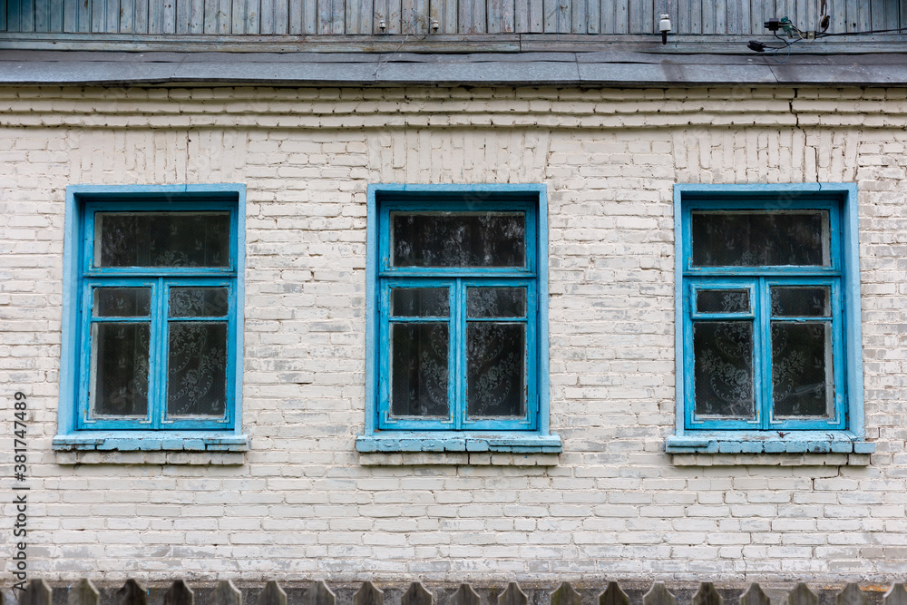 Three blue windows in a brick house