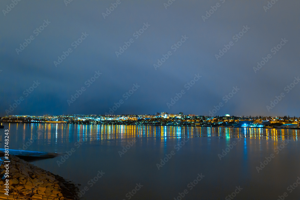 Fototapeta premium Night photo of Reykjavik city beach. Waterfront lights
