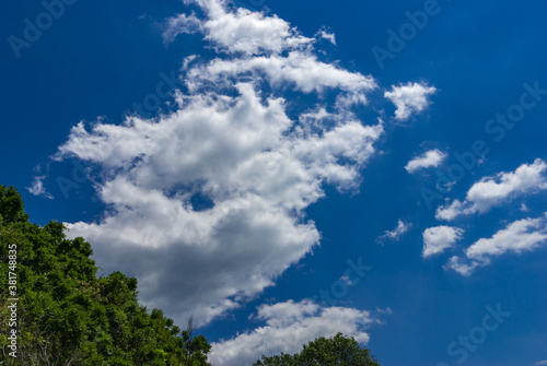 Green mountain against blue sky and white clouds