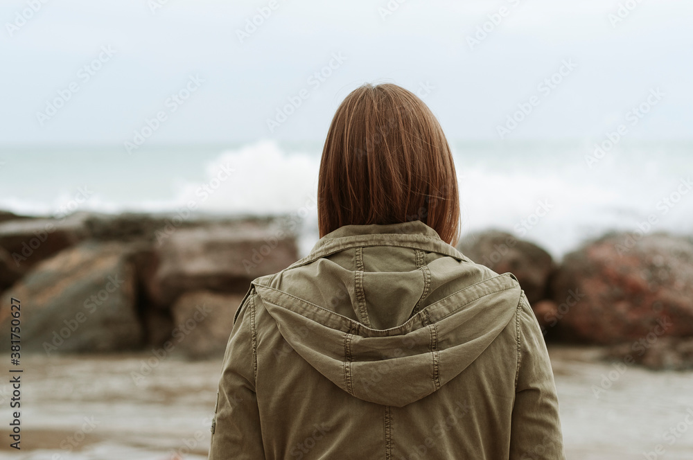 Young girl photographed on the beach on a rainy autumn day Young girl photographed on the beach on a rainy autumn day