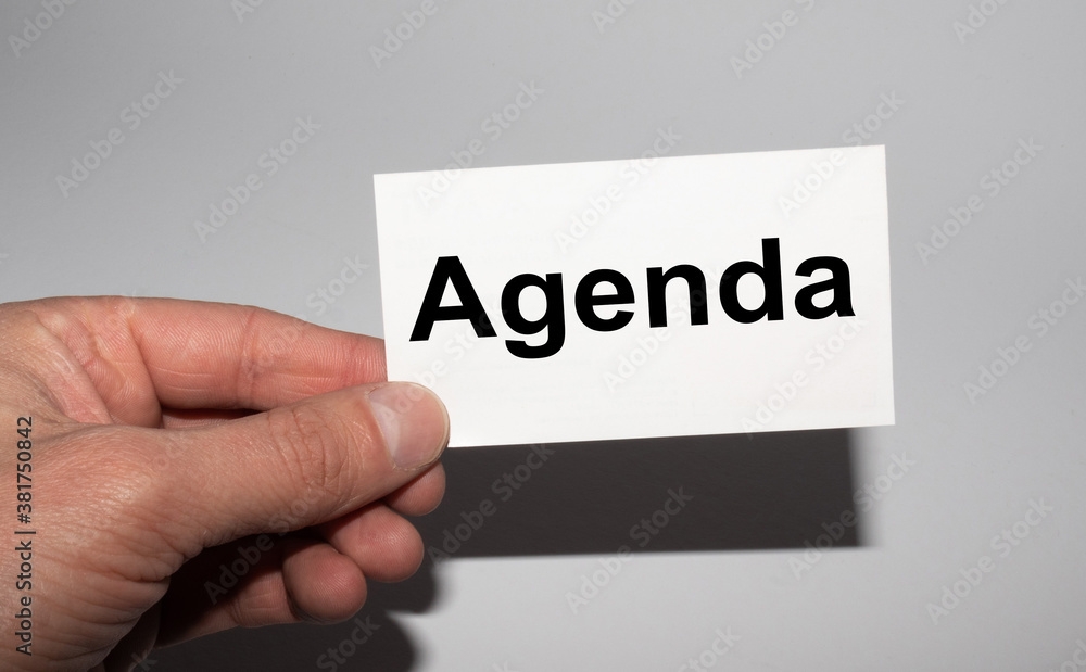 Message on the card AGENDA, in hands of businessman.