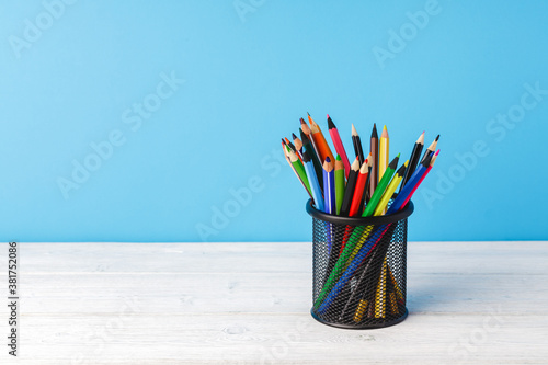 School supplies on wooden desk against blue background