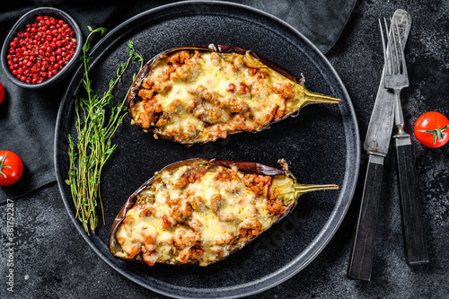 Baked eggplant with tomatoes and cheese. Black background. Top view