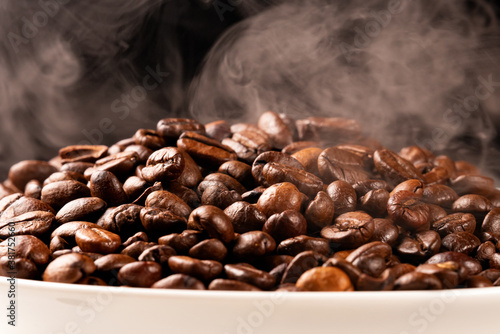 Freshly roasted coffee beans with smoke.