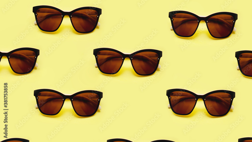 Sunglasses rows pattern on yellow background with the shadows