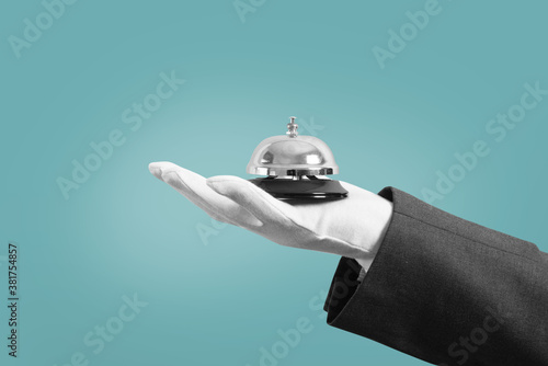 Waiter with bell in hand. Concept of first class service in your business. photo