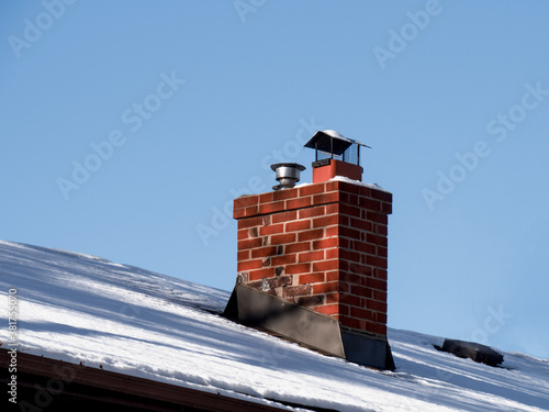 фотографія an old brick chimney on a snow covered rooftop