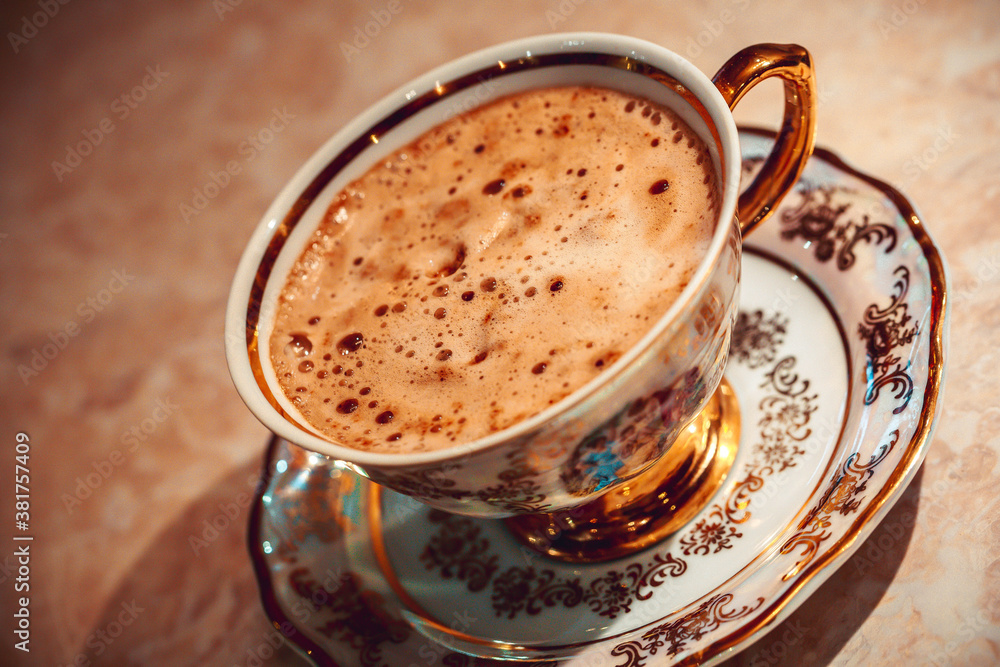 Obraz premium beautiful gold Cup of Cappuccino Coffee on the table