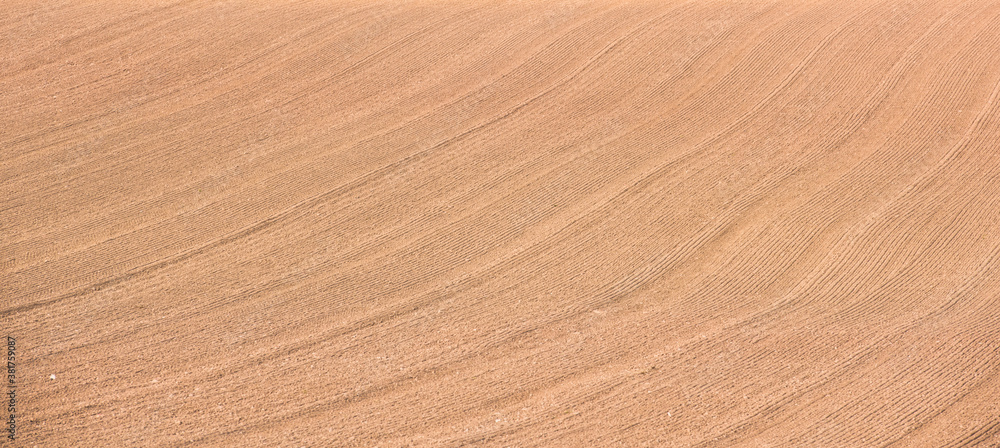 Rows of soil before planting.Furrows row pattern in a plowed field prepared for planting crops in spring Rows of soil before planting.Furrows row pattern in a plowed field prepared for planting crops in spring