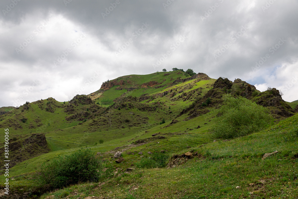 Mountain landscape with blue sky. Panoramic view of green hills.	