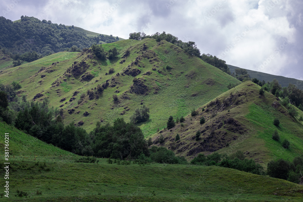 Mountain landscape with blue sky. Panoramic view of green hills.