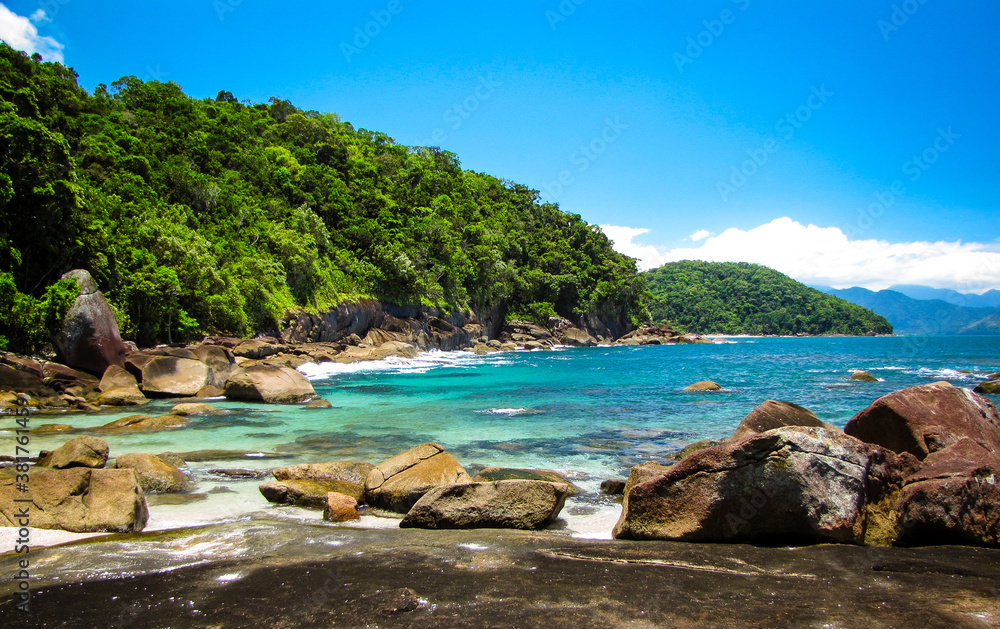 Rocks and blue water in a brazilian paradise beach - Praia das Conchas - Ubatuba - SP