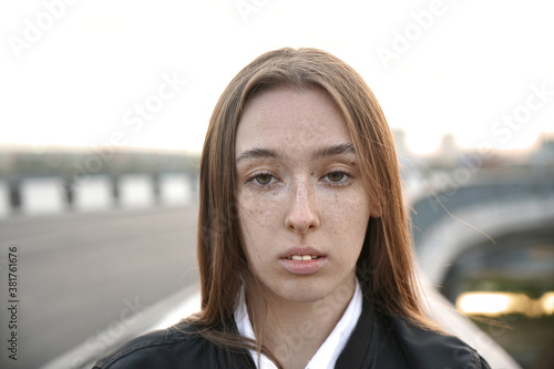 young silly crazy woman with brown hair making stupid faces on road background. young suicide girl. photo