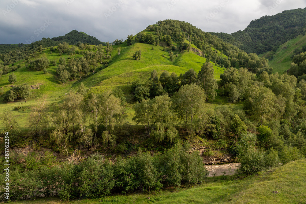 Obraz premium Mountain landscape with blue sky. Panoramic view of green hills.