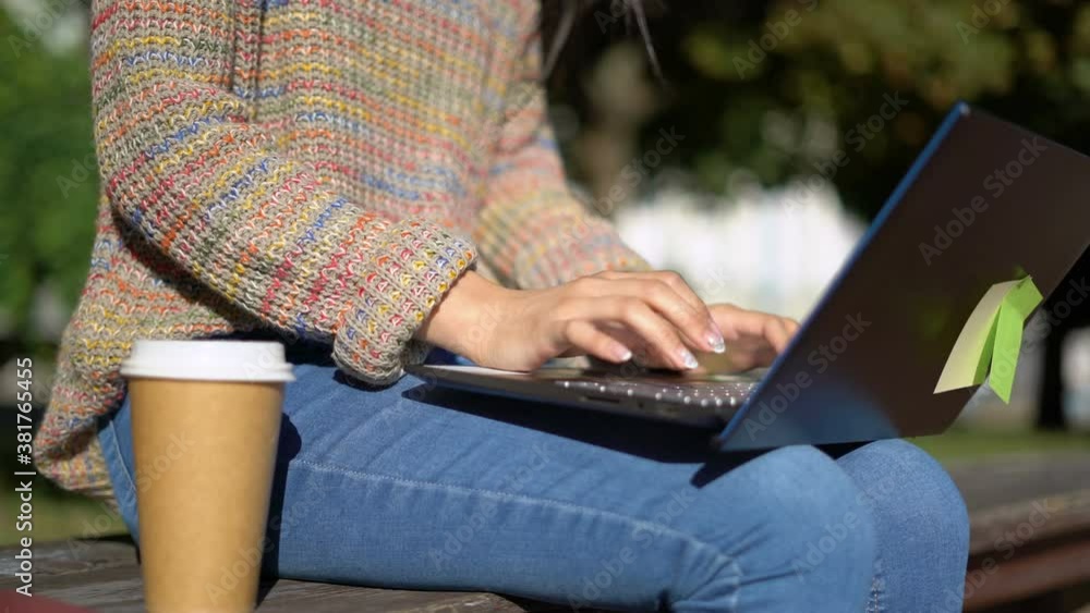 Female hands are typing on the keyboard. the girl is sitting on a bench. 4K Female hands are typing on the keyboard. the girl is sitting on a bench. 4K