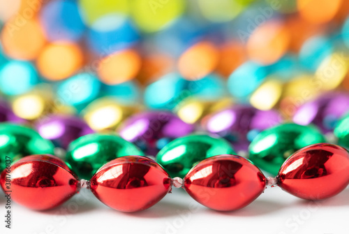 Original close up photograph of colorful mardi gras beads creating colored bokeh