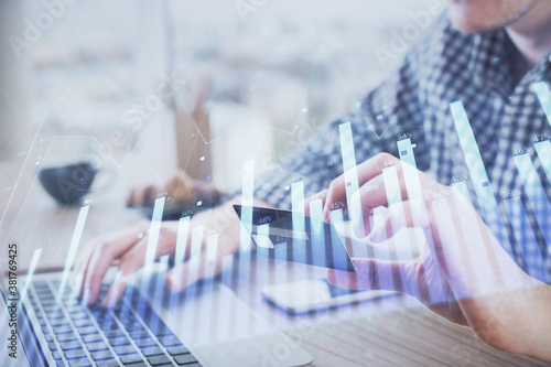 Double exposure of man hands holding a credit card and Forex graph drawing. Stock trading and digital fintech in Internet E-commerce concept.