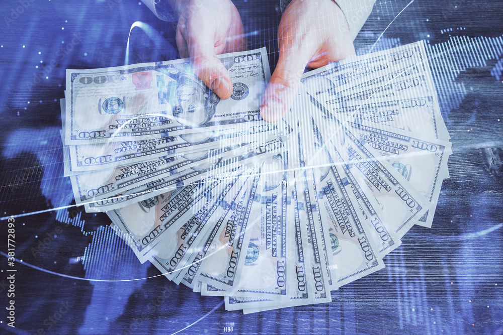 Multi exposure of financial graph drawing hologram and USA dollars bills and man hands. Analysis concept.