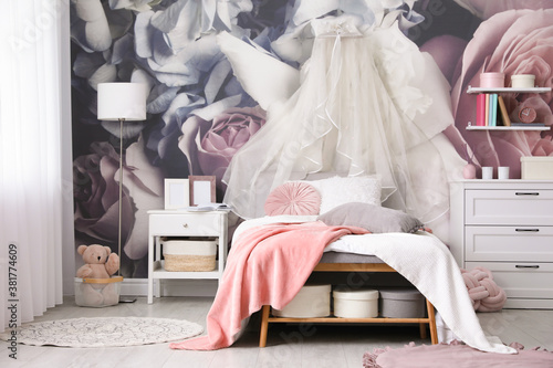 Teenage girl's room interior with comfortable bed and floral wallpaper. Idea for stylish design