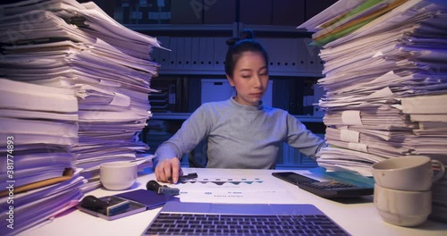 Asian business woman sitting at desk covered with stack of paperwork and talking phone, using laptop. Tired alone girl sleeping while working hard at late night. Time lapse, Fast speed, Web cam view