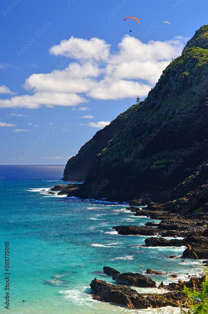 View of paragliders above the coastline of Oahu near Makapuu lighthouse in Hawaii. 