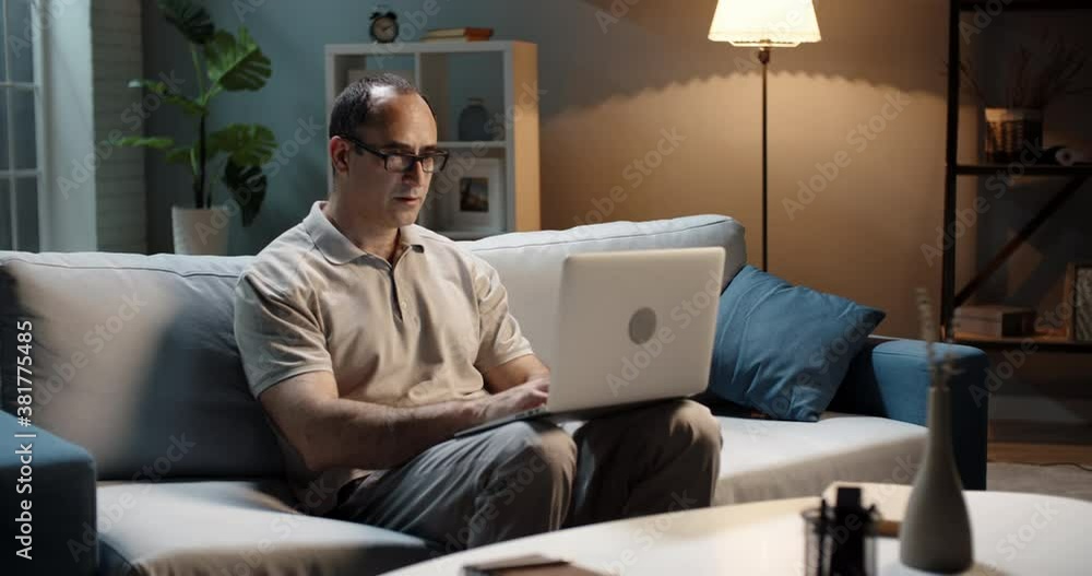 Successful male entrepreneur remotely working from home. Businessman using his laptop for surfing web and completing projects 4k footage Successful male entrepreneur remotely working from home. Businessman using his laptop for surfing web and completing projects 4k footage