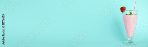 Tasty fresh milk shake with strawberry on light blue background. Space for text