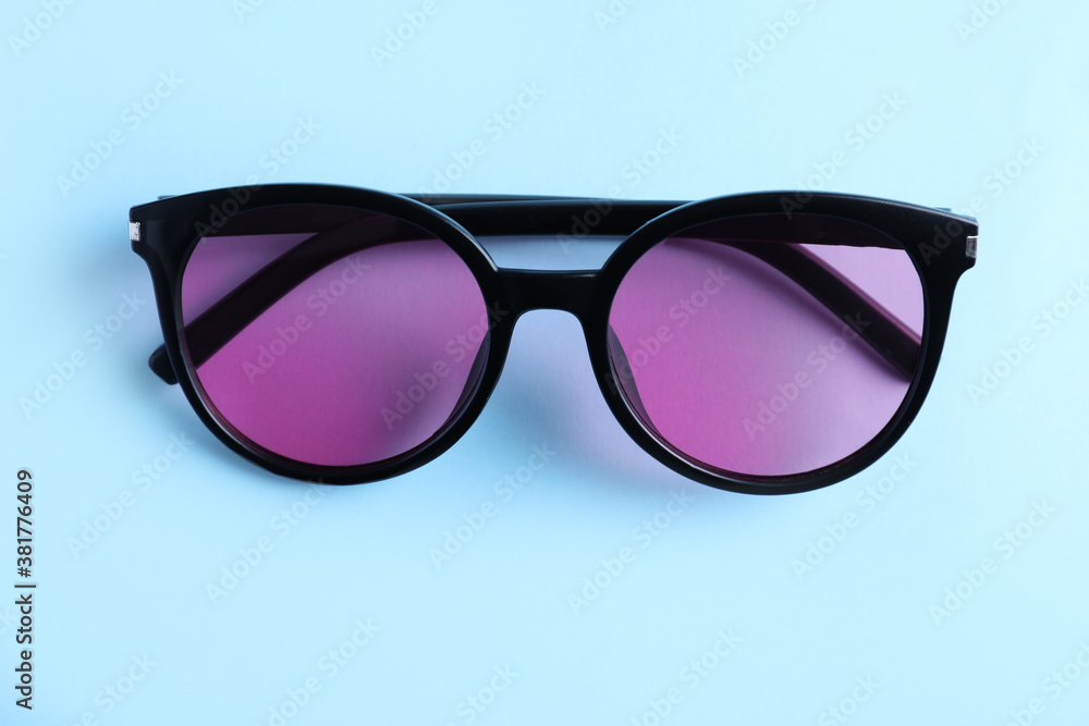 Stylish sunglasses on light blue background, top view Stylish sunglasses on light blue background, top view