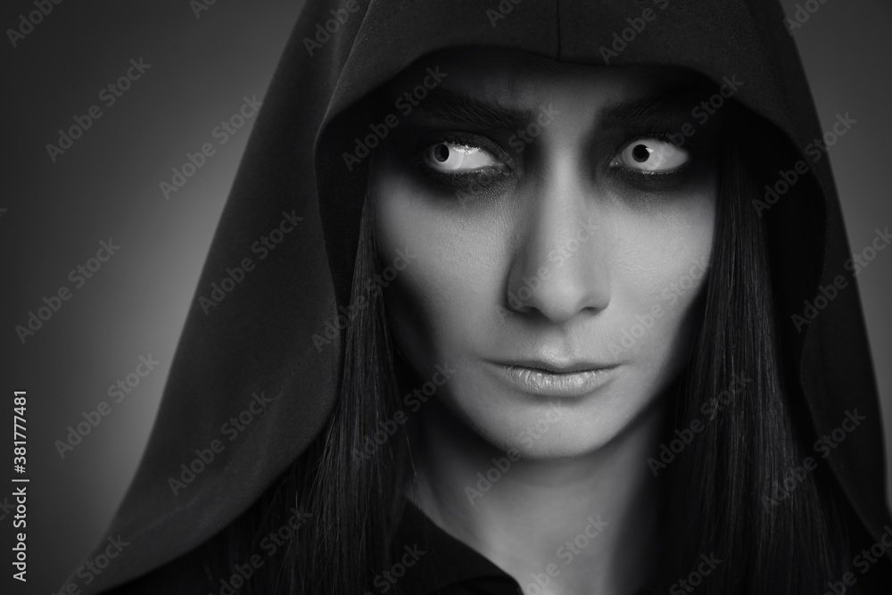 Mysterious witch with spooky eyes on dark background, closeup. Black and white effect Mysterious witch with spooky eyes on dark background, closeup. Black and white effect